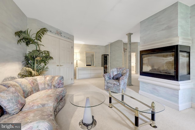 carpeted living area with decorative columns