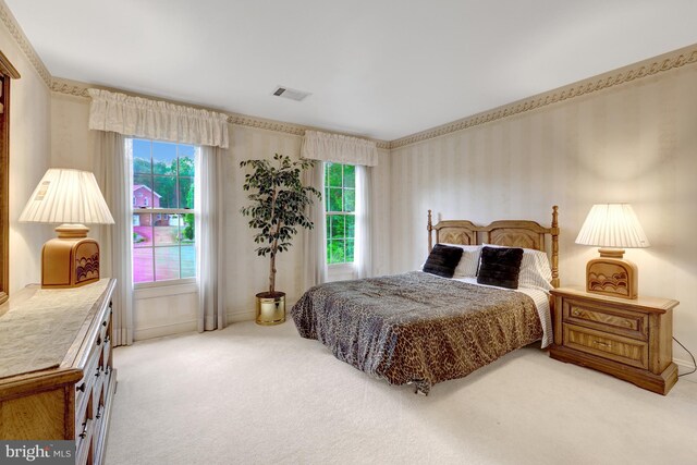 bedroom featuring wallpapered walls, visible vents, light carpet, and multiple windows