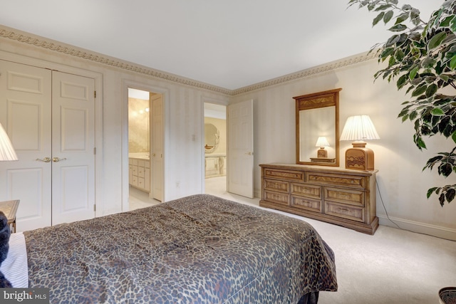 carpeted bedroom with ensuite bathroom, baseboards, and a closet