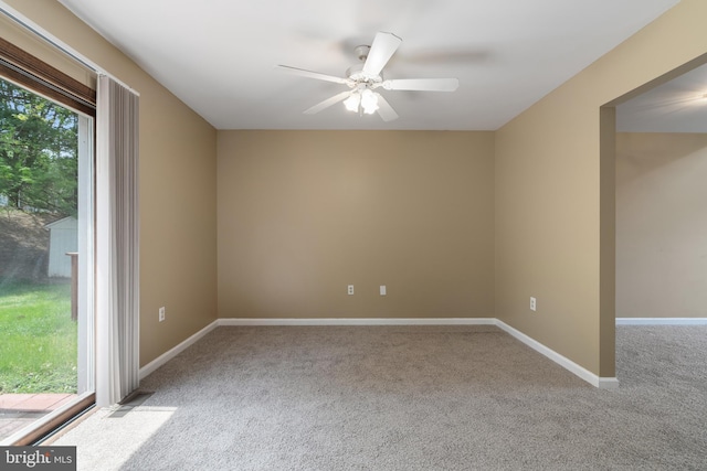 empty room featuring carpet flooring, ceiling fan, and baseboards