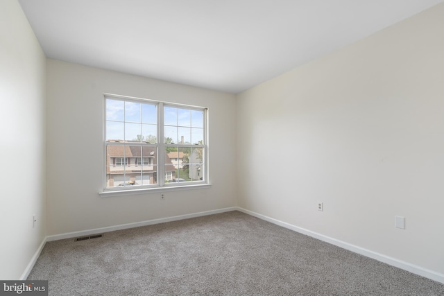 unfurnished room featuring carpet floors, baseboards, and visible vents