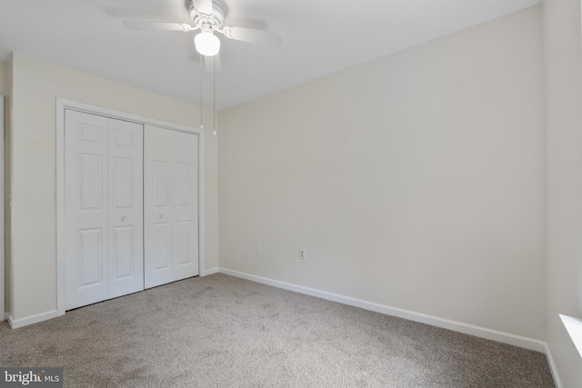 unfurnished bedroom with carpet floors, a ceiling fan, baseboards, and a closet