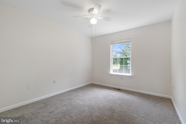 empty room with carpet flooring, ceiling fan, and baseboards