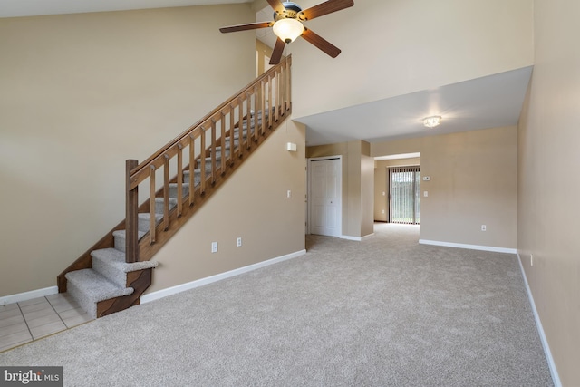 unfurnished living room featuring a ceiling fan, stairway, carpet floors, baseboards, and high vaulted ceiling