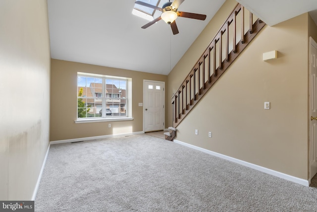 foyer entrance with ceiling fan, carpet, stairs, baseboards, and lofted ceiling