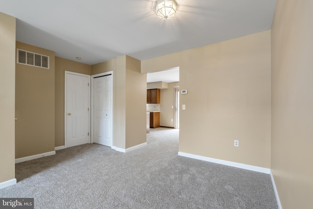 unfurnished bedroom with light colored carpet, baseboards, visible vents, and a closet