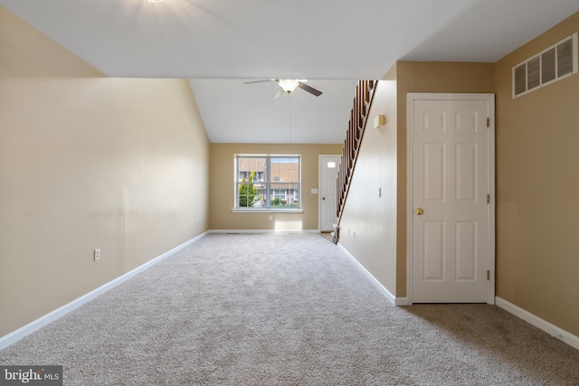 carpeted spare room featuring baseboards, ceiling fan, stairs, and visible vents