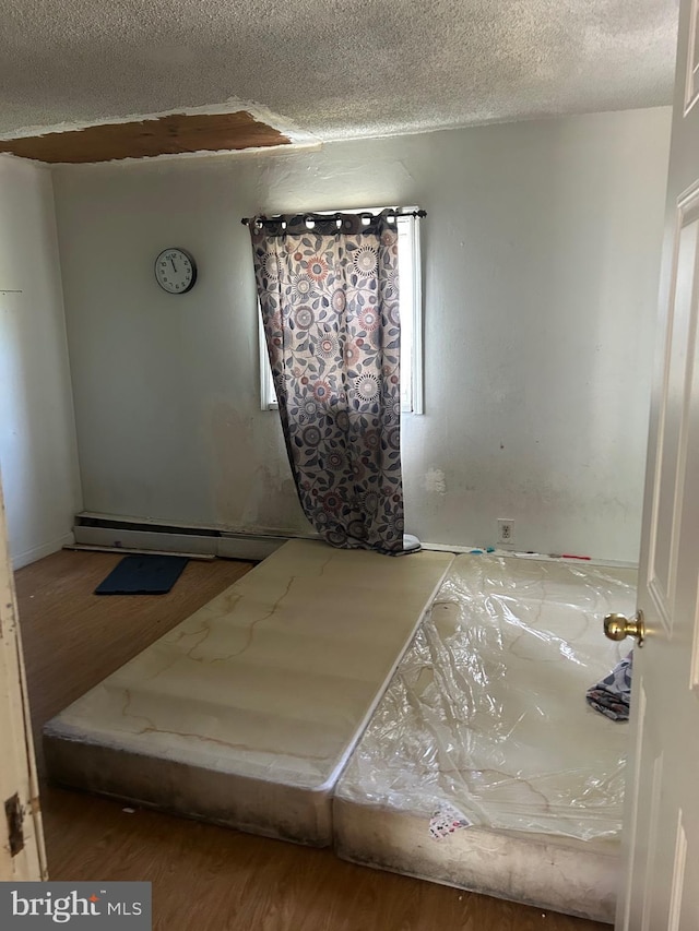 unfurnished bedroom featuring a textured ceiling and wood finished floors