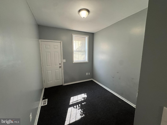unfurnished room with baseboards