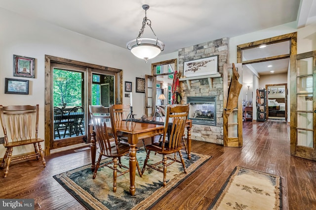 dining space featuring a fireplace, a wealth of natural light, and wood-type flooring