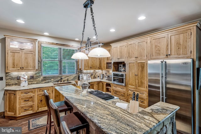 kitchen with recessed lighting, a kitchen breakfast bar, decorative backsplash, and appliances with stainless steel finishes