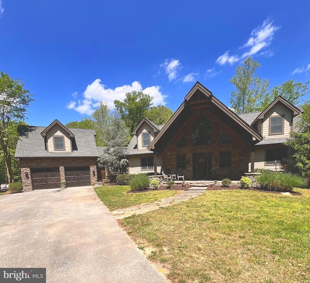 view of front of home featuring a front yard, driveway, and stone siding