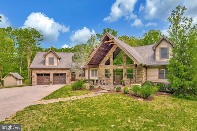 craftsman-style home with driveway, a front yard, a garage, a shingled roof, and stone siding