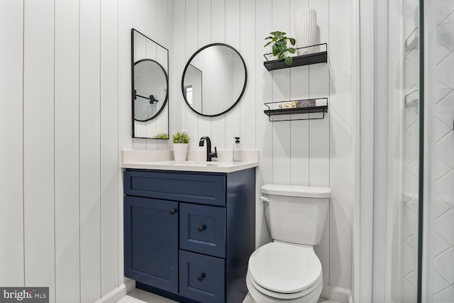 bathroom featuring toilet, vanity, and baseboards