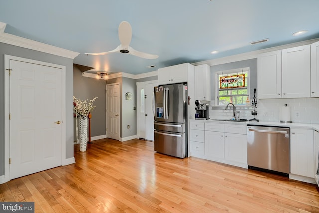 kitchen featuring visible vents, ornamental molding, a sink, appliances with stainless steel finishes, and backsplash
