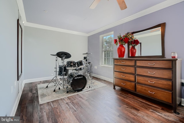 interior space featuring a ceiling fan, baseboards, dark wood finished floors, and ornamental molding