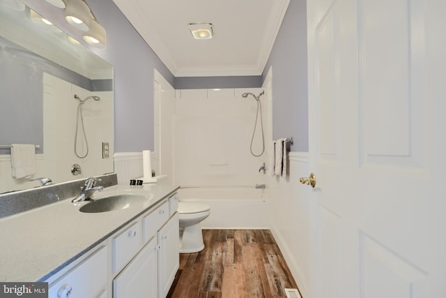 bathroom with toilet, ornamental molding, a wainscoted wall, and a decorative wall