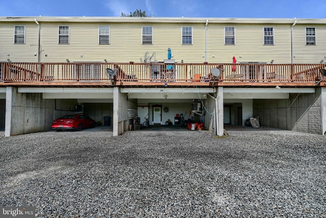 rear view of property with a carport, driveway, and a deck