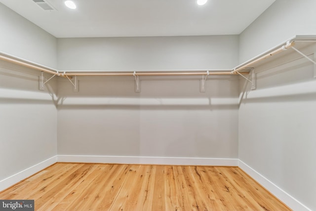 spacious closet featuring visible vents and wood finished floors