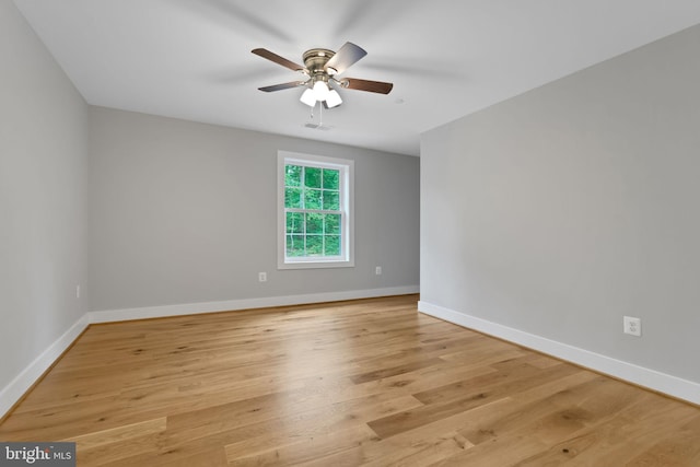 unfurnished room with a ceiling fan, baseboards, visible vents, and light wood-style flooring