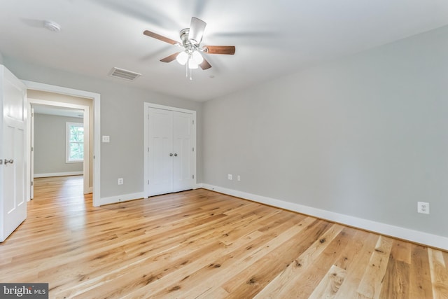 unfurnished bedroom with a ceiling fan, baseboards, visible vents, and light wood finished floors