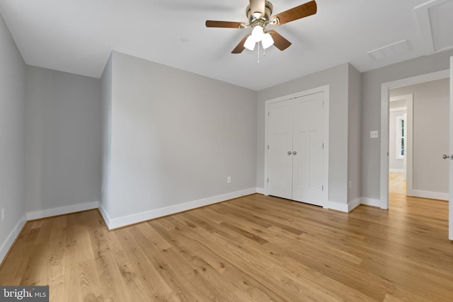 unfurnished bedroom with baseboards, visible vents, light wood finished floors, and a closet
