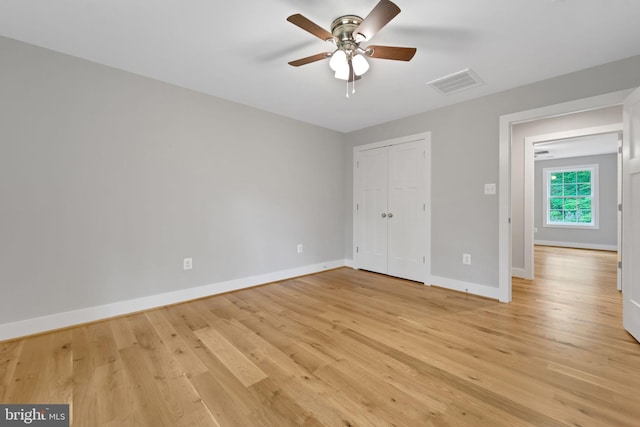 unfurnished bedroom with visible vents, a closet, baseboards, ceiling fan, and light wood finished floors