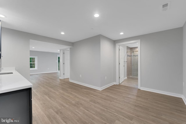 unfurnished living room featuring light wood-type flooring, recessed lighting, baseboards, and visible vents