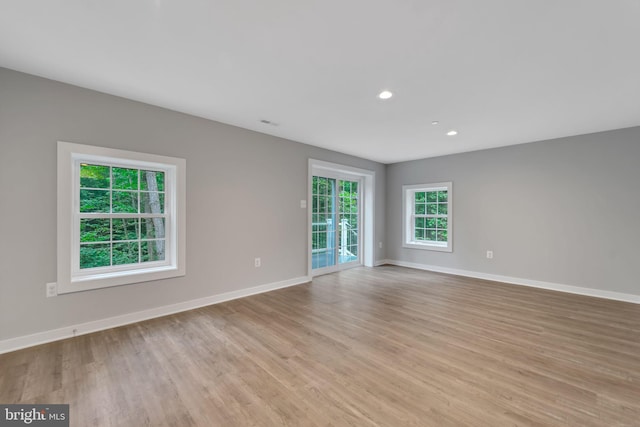 unfurnished room with recessed lighting, baseboards, and light wood-type flooring