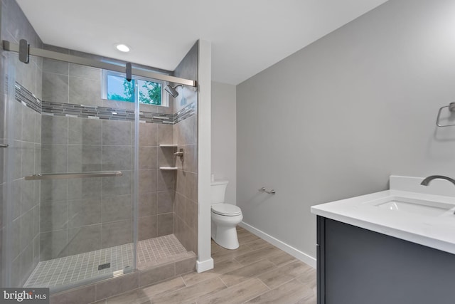 full bath with baseboards, wood tiled floor, a shower stall, and toilet