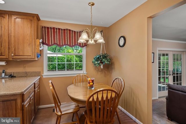 dining space featuring crown molding, baseboards, and a chandelier