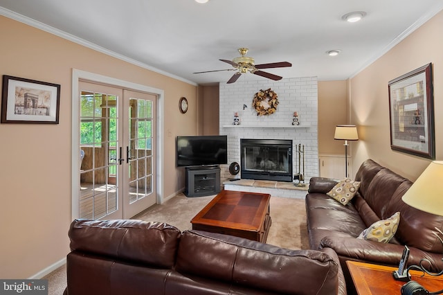 living room with a ceiling fan, a fireplace, carpet floors, baseboards, and ornamental molding