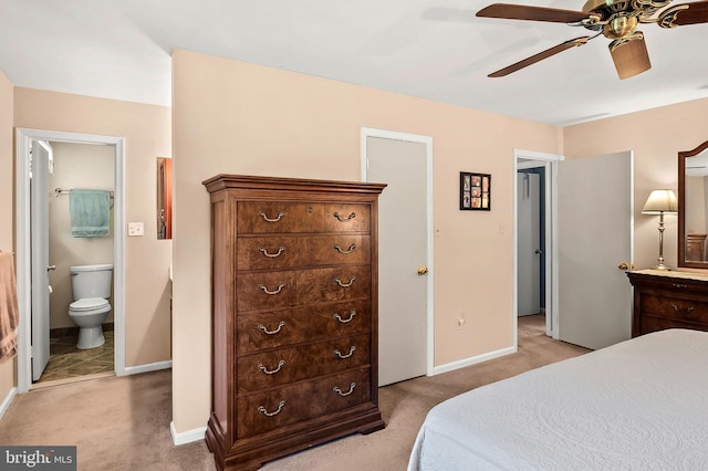 bedroom with baseboards, ceiling fan, light carpet, and connected bathroom