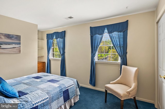 carpeted bedroom featuring visible vents, baseboards, and multiple windows