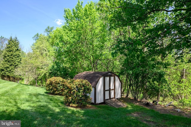 view of yard with a storage shed, a view of trees, and an outdoor structure