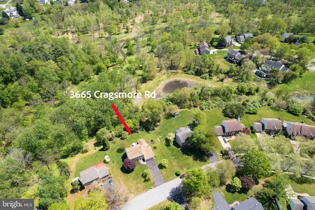 birds eye view of property featuring a wooded view and a residential view