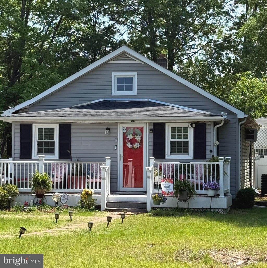 view of front of house with covered porch and a front lawn