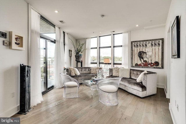 living area featuring recessed lighting, baseboards, wood finished floors, visible vents, and expansive windows
