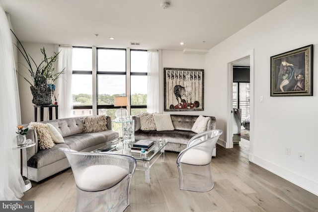 living area featuring visible vents, wood finished floors, baseboards, recessed lighting, and expansive windows