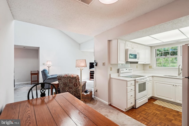 12116 Greenway Ct Unit 302, Fairfax, VA 22033 - kitchen featuring white cabinets, a sink, white appliances, light countertops, and vaulted ceiling