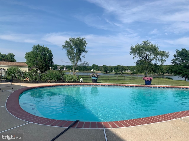 outdoor pool featuring a lawn and fence