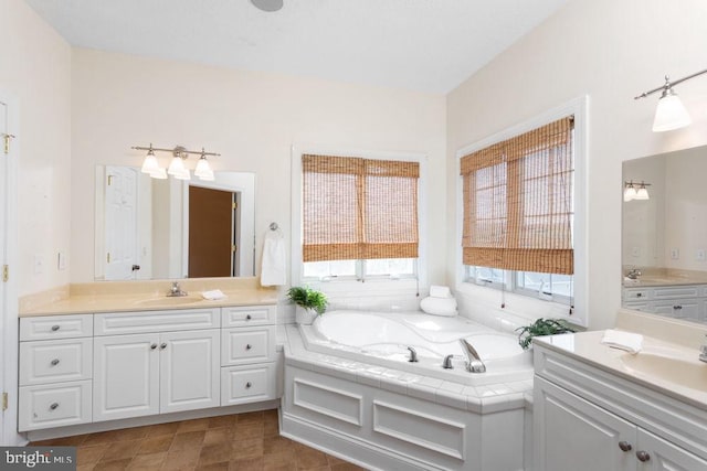 bathroom with a sink, a bath, and two vanities