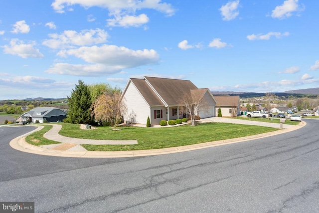 view of front of home featuring a front lawn, a mountain view, and driveway