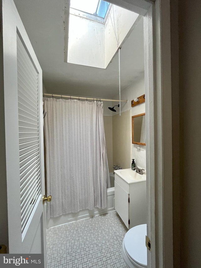 full bathroom with vanity, shower / bath combo with shower curtain, toilet, and a skylight