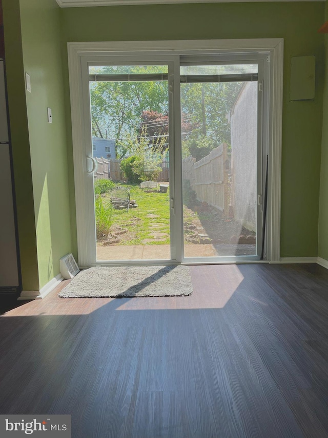 doorway to outside featuring baseboards, wood finished floors, and a wealth of natural light