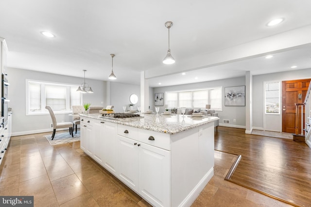 kitchen with baseboards, recessed lighting, white cabinetry, and open floor plan