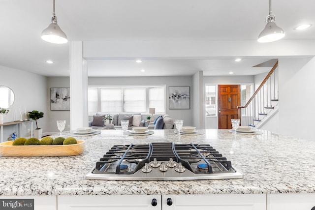 kitchen with recessed lighting, open floor plan, light stone countertops, and stainless steel gas stovetop