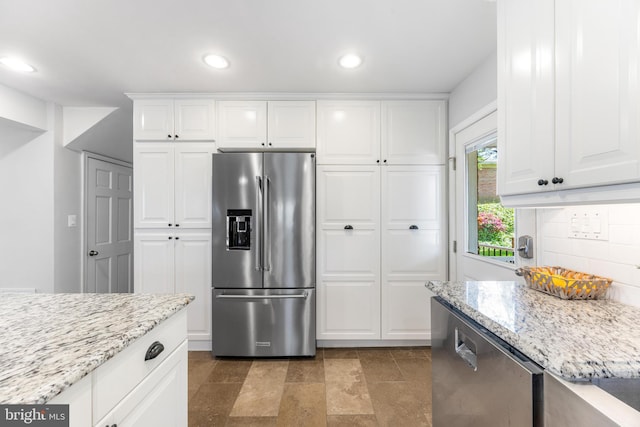 kitchen with light stone counters, white cabinets, tasteful backsplash, and stainless steel appliances