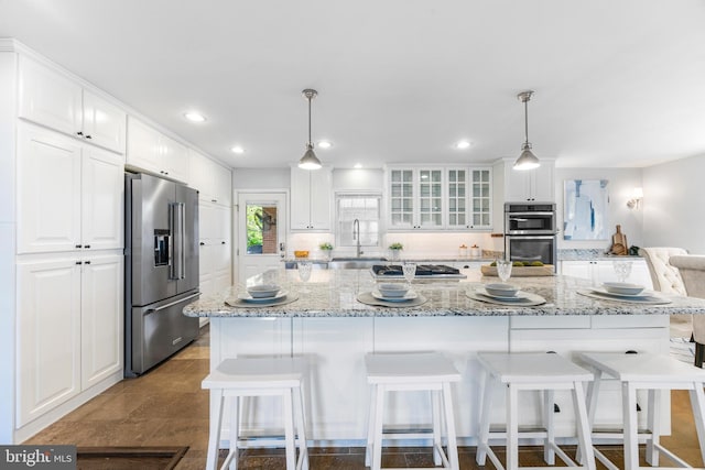 kitchen featuring appliances with stainless steel finishes, a sink, white cabinets, glass insert cabinets, and recessed lighting