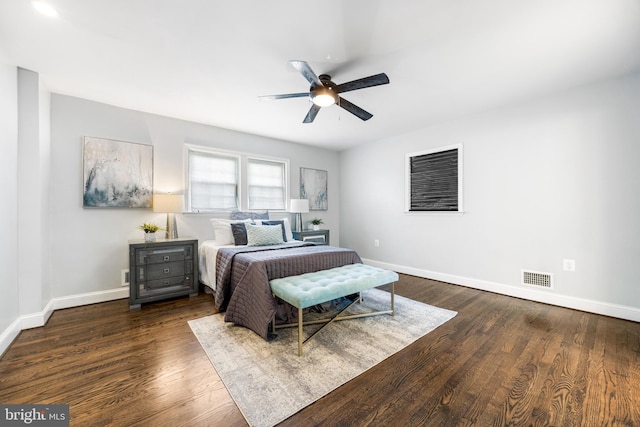 bedroom featuring baseboards, a ceiling fan, wood finished floors, and visible vents